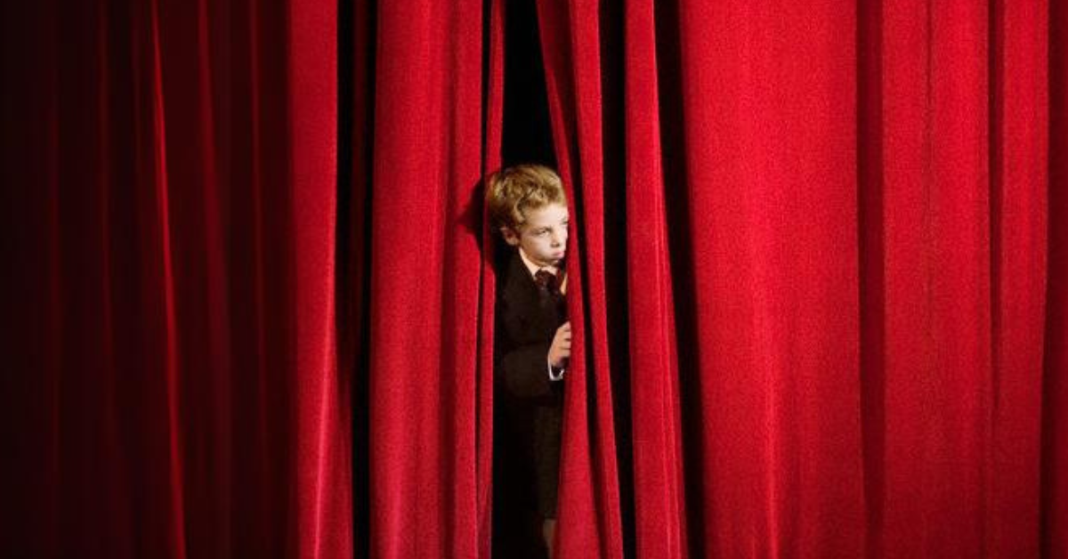 A child standing on the stage with stage fear