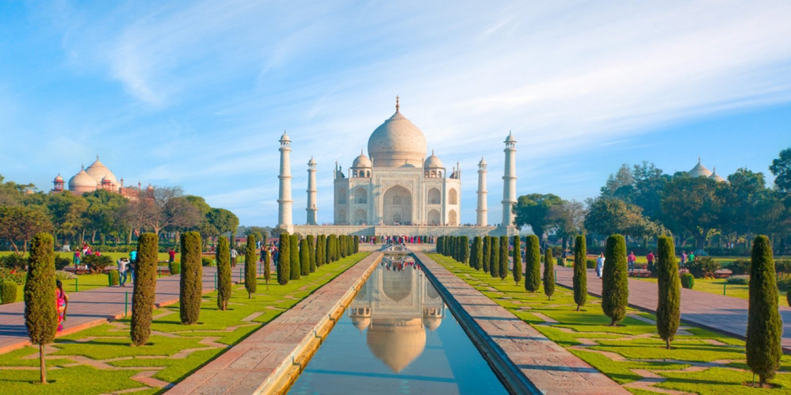 Tourists visiting the Taj Mahal gardens at sunrise